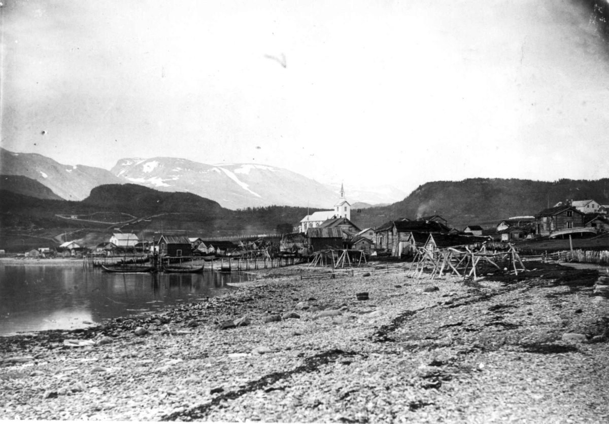 Oversiktsbilde over Talvik med bebyggelse og Talvik kirke, båter i havna, 1892.