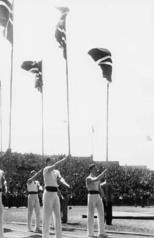 Fra Oslo under fredsdagene i 1945. Idrettens Dag på Bislett Stadion 3.juni Idrettsmenn med flaggborg på den oppmerkede banen.