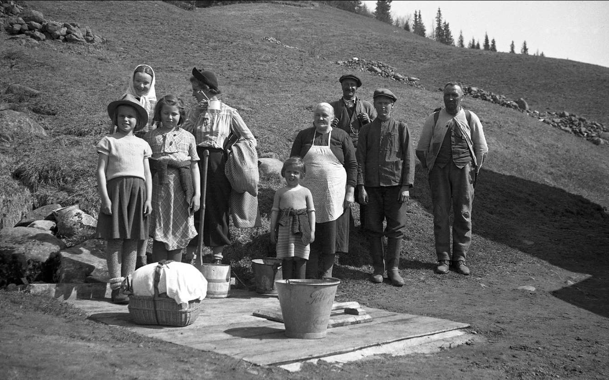 Dordi Arentz og døtrene Guri, Siri og Kari står sammen med familien Åslein ved brønnen på Ligardshaugen 1940.