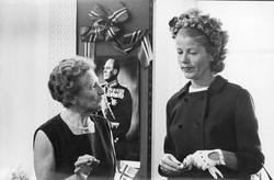 Utstillingdeltakere forann portrett av Kong Olav.