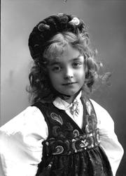 Studioportrett av pike i drakt og lue.