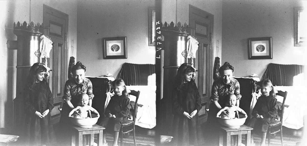Interiør, Munkedamsveien 3, Oslo, 1903. Familie, mor Margrethe Quinsgaard  Wiborg med barn, spedbarn blir badet i balje. 