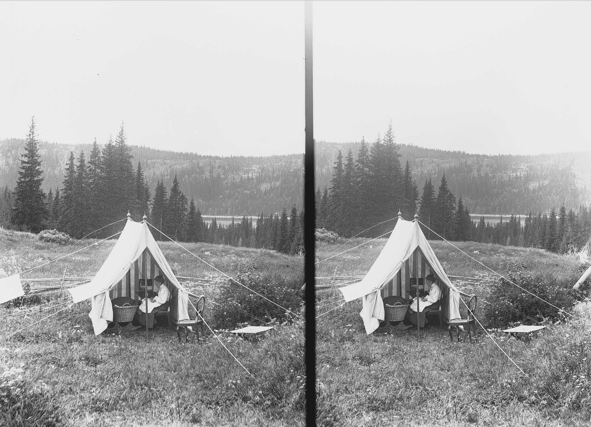 Margrethe Q. Wiborg sitter i telt med kurv ved Holoa seter, Hadeland, Jevnaker, Oppland, 1903. Utsikt til Skarvvannet.