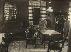 Interiør med stoler, sofa, skap, speil og gardiner, muligens