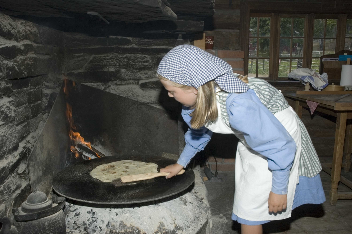 Levendegjøring på museum.
Ferieskolen uke 31. Baking av lefser i eldhuset fra Bakke, NF024.
Norsk Folkemuseum, Bygdøy.