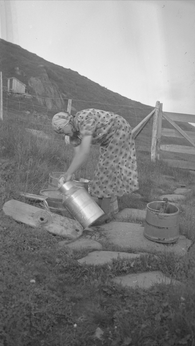 Kvinne vasker melkeutstyr, Liabøsætra, Oppdal, Sør-Trøndelag. Fotografert 1937. 