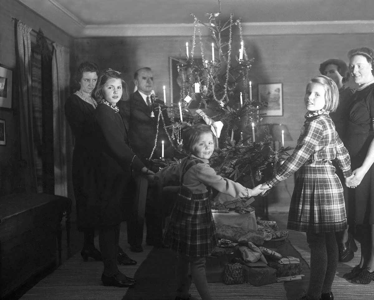 Familien Arentz går rundt juletreet på julaften. Fotografert 24. desember 1939.