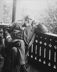 Avfotografering. Portrett, mann i dress i en kurvstol på ver