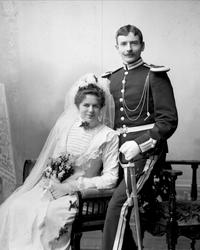 Gruppe, bryllupsbilde, brud i hvit kjole, brudgom i uniform.