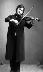 Portrett, kvinne i herreklær spiller fiolin. Fiolinist(?)