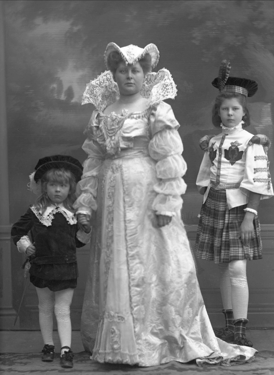 Gruppeportrett, Contance Wiel Nygaard (1866-1931) med barna Lizzie og Andreas kledd for maskeradeball, Oslo, 1908.