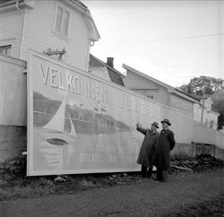 Langesund, Bamble, mai 1955. To menn foran skilt  med velkom