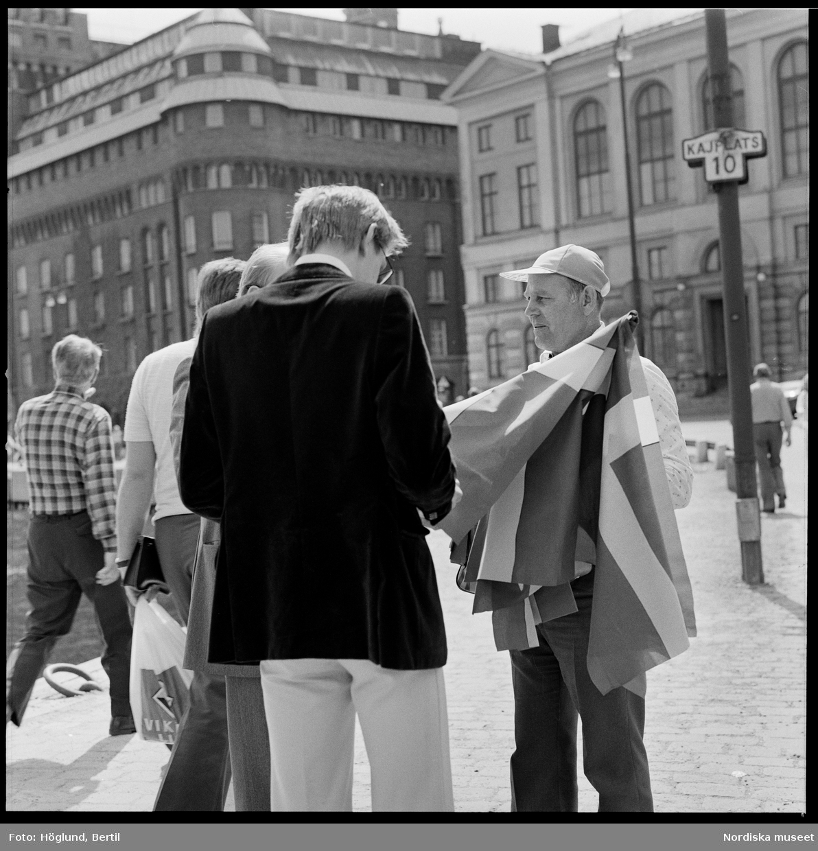 Kungabröllopet den 19 juni 1976, Carl XVI Gustaf gifter sig med Silvia Sommerlath. Dokumentation av människor längs kortegevägen. Åskådare, flaggförsäljare.