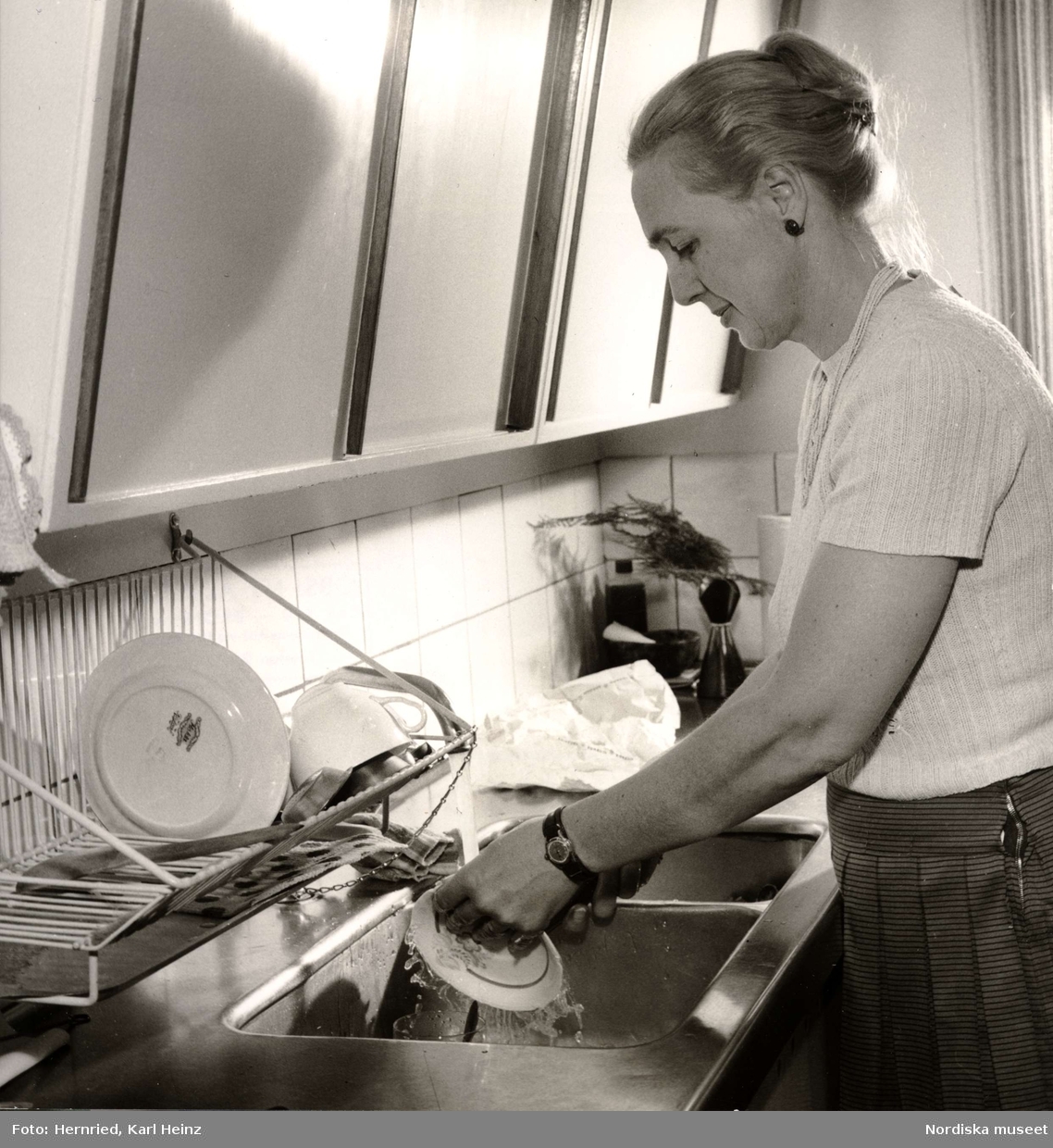 Kök. Kvinna som diskar.