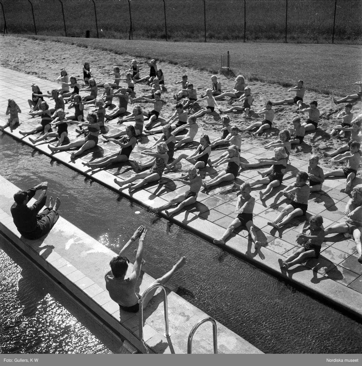 Simundervisning på bassängkant, Älvsjöbadet, Stockholm.