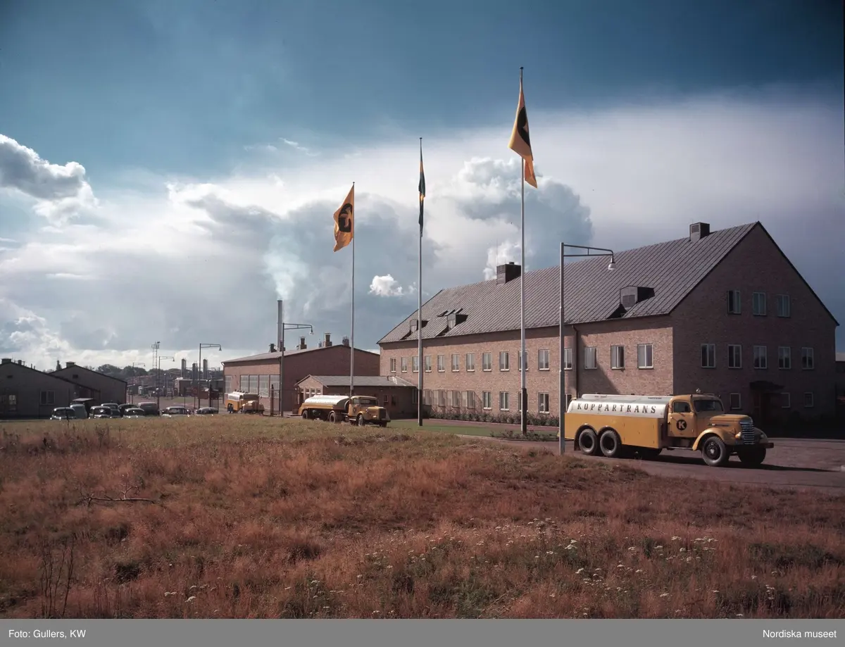 Tre tankbilar, Koppartrans, på rad med gula tegelbyggnader i bakgrunden. Göteborg.