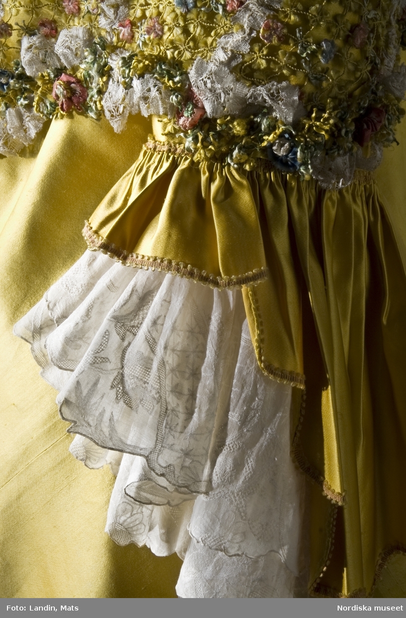 Dräkt av gul atlas med silkebroderier. 1700-talets mitt. Nordiska museet inv nr 171126.