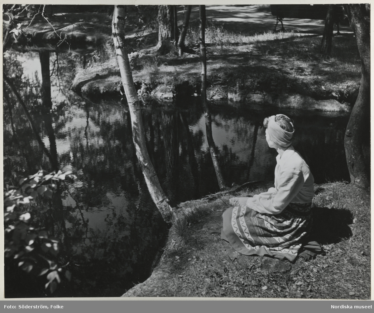 Kvinna sittande vid tjärn, Småland