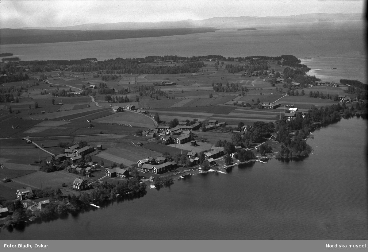 Flygfoto över landskap. Enligt påskrift på monteringen "Boda? norr Leksand". Enligt beställarenär det fotograferade området Laknäs