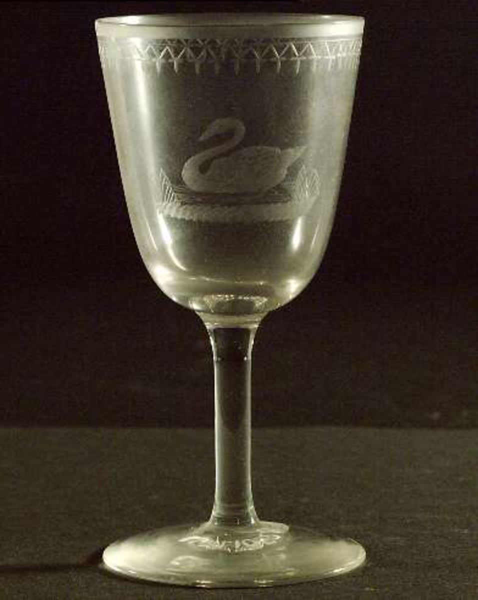 Sherryglas av ofärgat glas med etsad kant och graverad bård och svan.