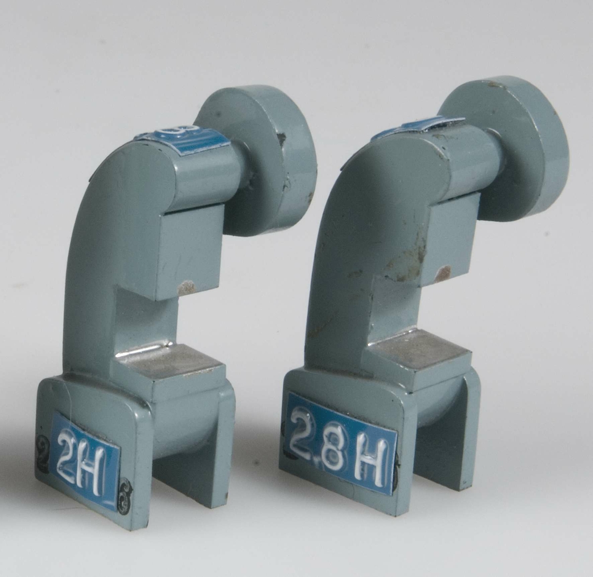 Två små maskinmodeller av trä målade ljusblå med grå detaljer. Blåvit dynamoremsa med nr 139 och 2,8 resp 148 2 H.
