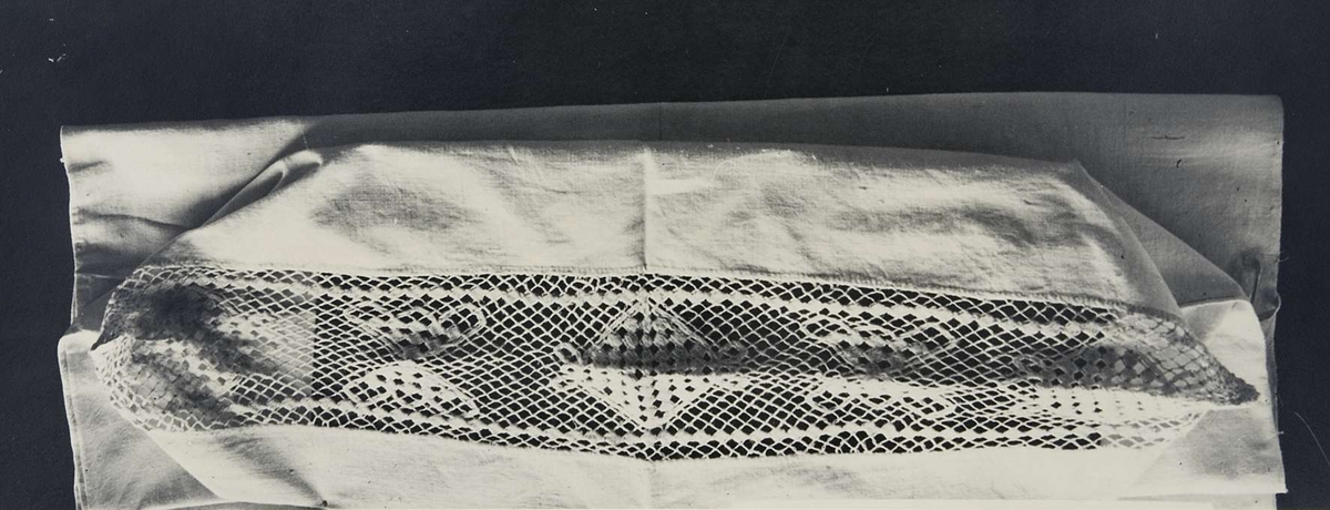 Fotografi av ett örngott med knuten och trädd spets. Fotografiet är märkt "A.172." i övre högra hörnet. Nedanför bilden finns signaturen "LZ" och numret "9565".