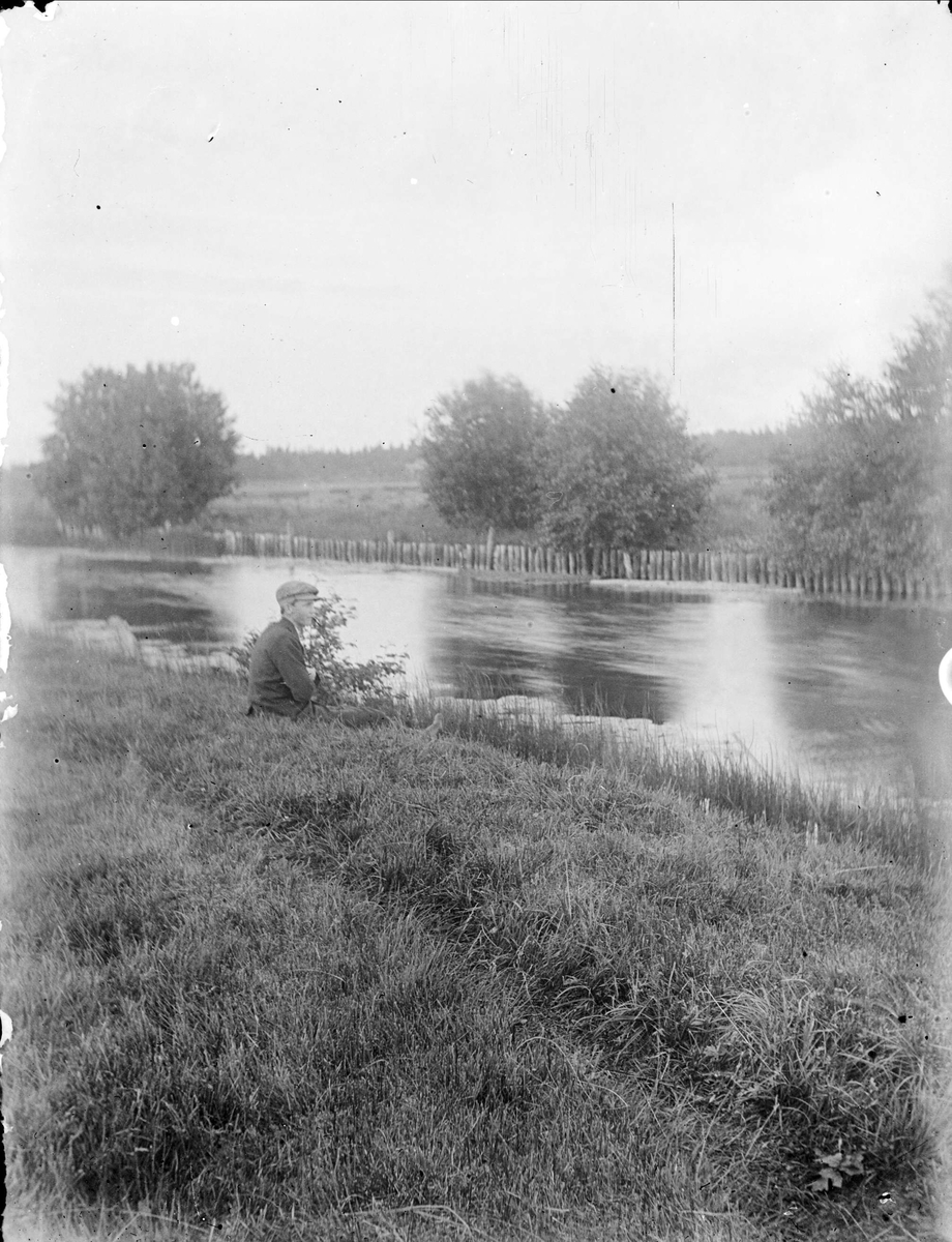 Pojke vid vattendrag, sannolikt Tämnarån, Tierpstrakten, Uppland omkring 1915 - 1920