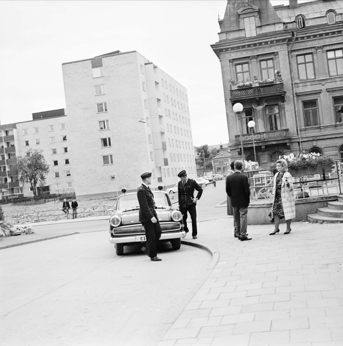 "Lugn' sommarkväll jobbig för radiopolisen" - poliserna Inge Ivarsson och Ove Brunn har stannat vid Uppsala busstation på Kungsgatan för en rutinkontroll, 1964