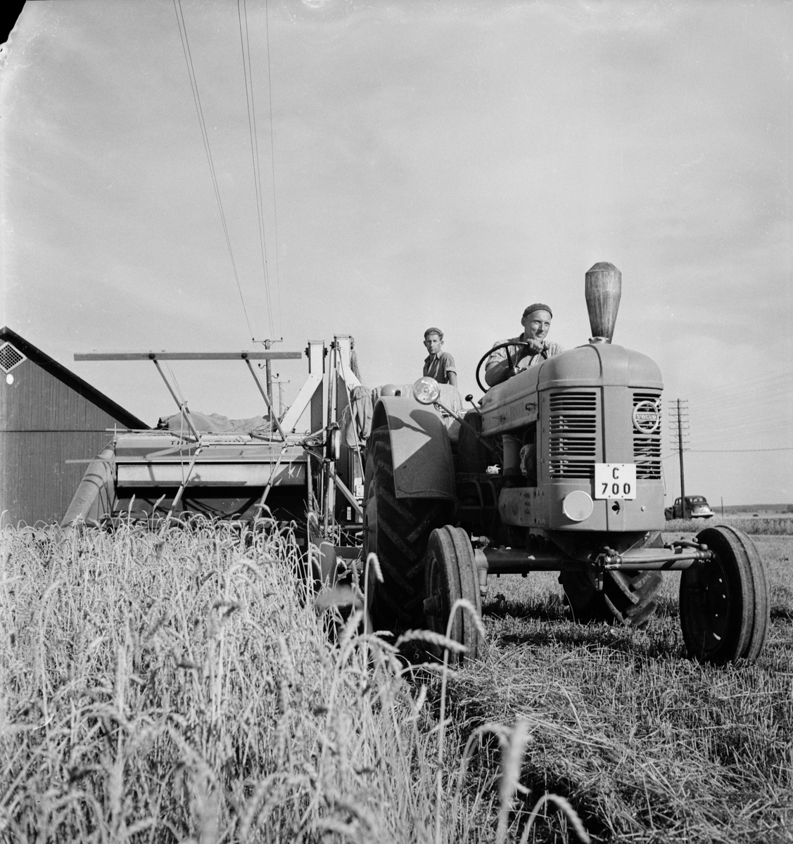 Lantbrukare Birger Landfelt vid ratten och lantbruksarbetare K Pettersson vid säckarna, Glädjen, nära Kungsängens gård