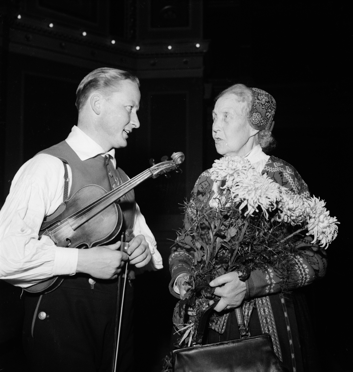 Spelmannen Nils Presto och eventuellt Delsbostintan på spelmansstämma i Universitetsaulan, Uppsala november 1949