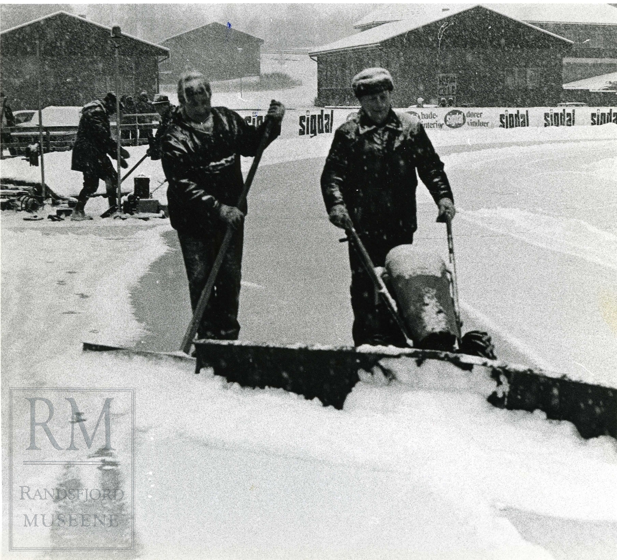 Banemannskap rydder skøytebanen på Brandbu stadion/rosendalsbanen for snø under EM på skøyter damer allround 1973