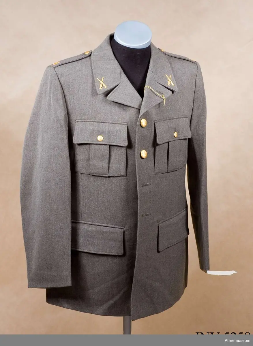 Skick som ny. Storlek: 100 U. Av samma snitt som uniform m/1939. Daglig dräkt av gråbrungrönt tyg. Bärs till mörkt gråbrungröna byxor. Tjänstetecken mattförgyllda.