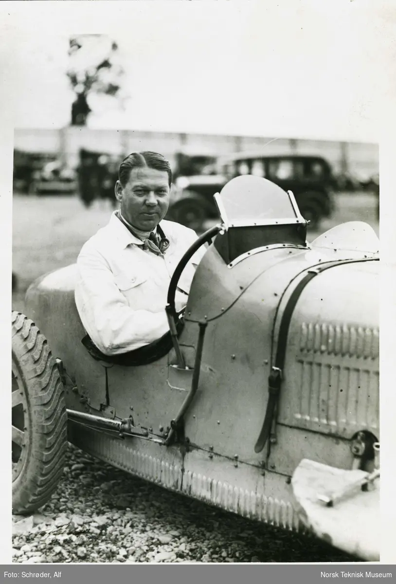 John Erik Isberg med hvit jakke bak rattet på sin Bugatti.