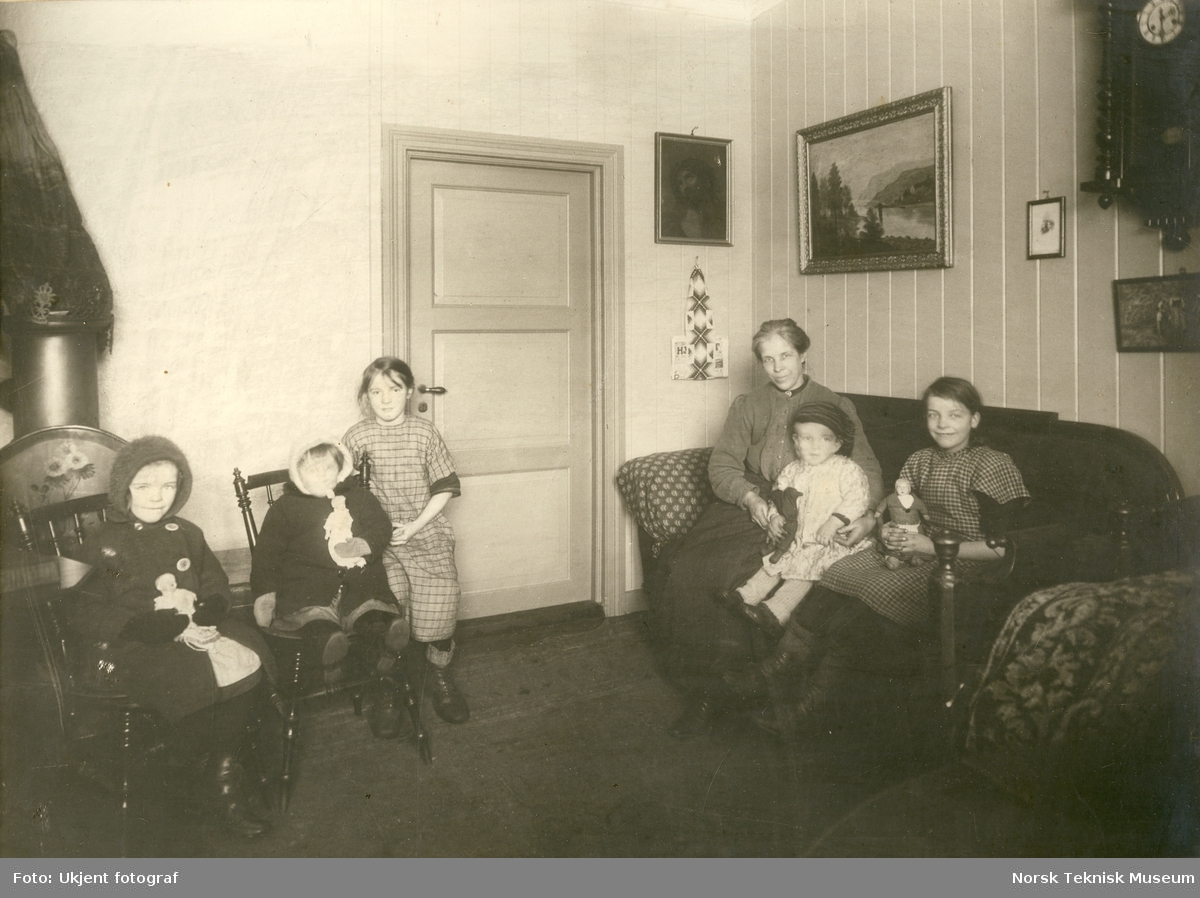Mor med fem barn fotografert i stuen i leilighet i Stavangergaten, Oslo. Bilde brukt i Barselhjemustillingen 1916
