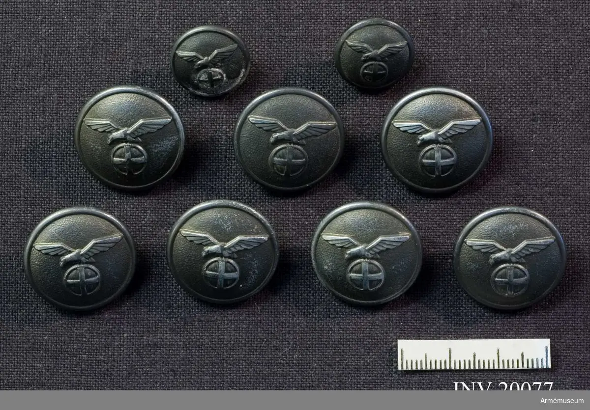 Nio knappar i två olika storlekar, av grå metall dekorerade med ett solkors krönt av en örn. Nasjonal Samling, Norge (1940-45), 7 större och och 2 mindre delar.