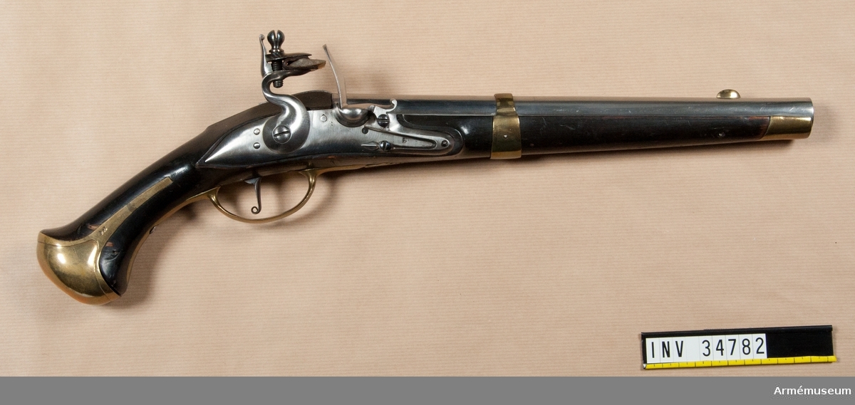 Grupp E III.
1802 års reparationsmodell från 1738 års pistol, med flintlås. Stämpel på låset med bokstäverna P B eller P R. Beslag av mässing. På stockens vänstra sida bakom sidblecket finns Krigskollegiums sigill i rött lack.