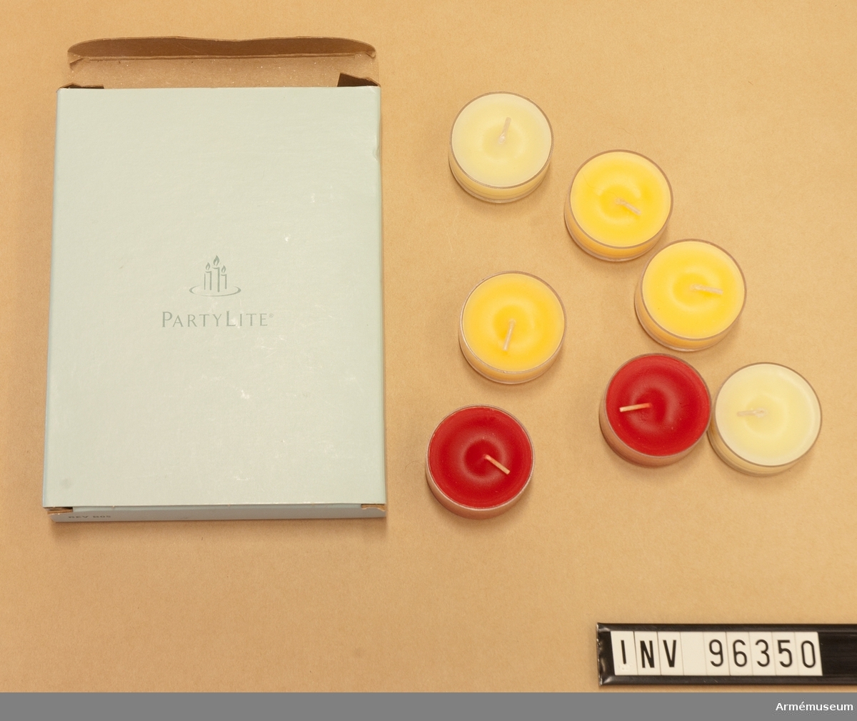 Kartong märkt "Party Lite" med 5 stycken små doftljus; tre orange, två röda och två gula.