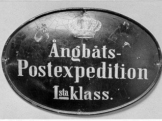 Skylt för ångbåtspostexpeditioner av första klass, oval
formmed text "Ångbåts Postexpedition 1sta klass. " i tre rader,
övertexten en kunglig krona. Skylten infördes 1883 och användes till
1915då klassindelningen slopades.