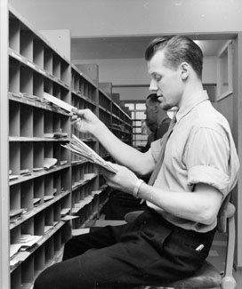 Försortering av korsband och tidningar på
brevbärarexpeditionen, postkontoret Malmö 8. Foto 18/4 1962. Försortering av brev.