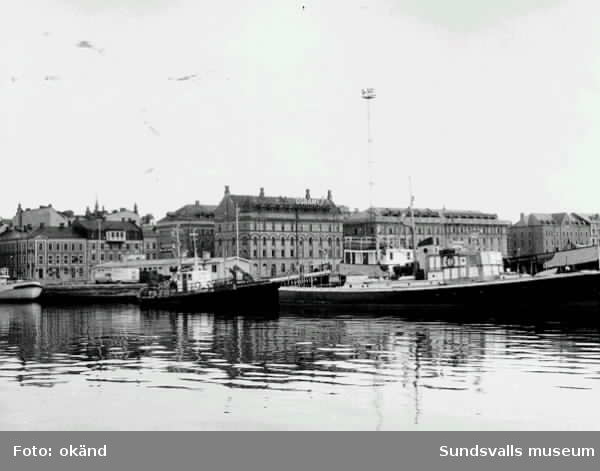 En SCA-båt samt  (Styrbjörn?) och Flottisten vid kajen i Sundsvall. Troligen innan E4 byggdes (1964).