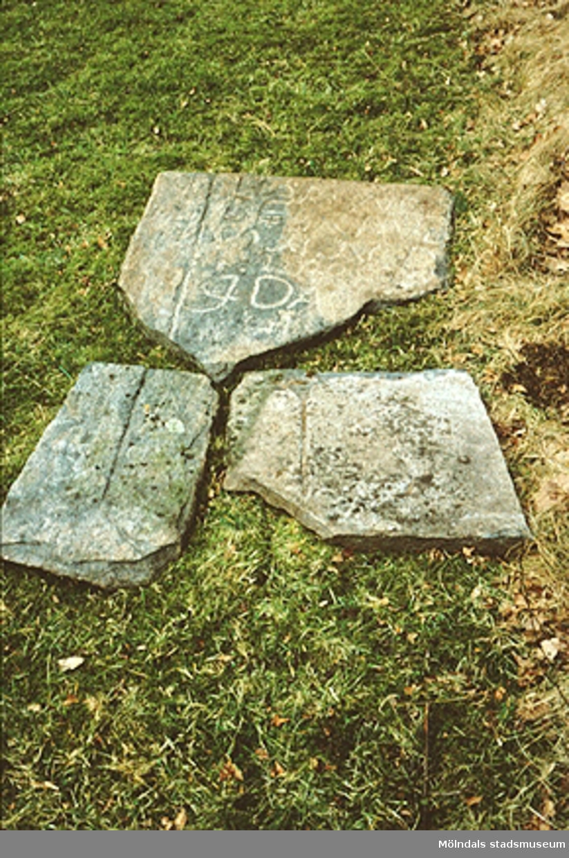 Gammal gravsten på Anders Karlssons tomt på Torkels väg 13 i Dvärred, mars 1993. Relaterade motiv: 2003_0039 - 0042 samt 2003_0376 - 0377.