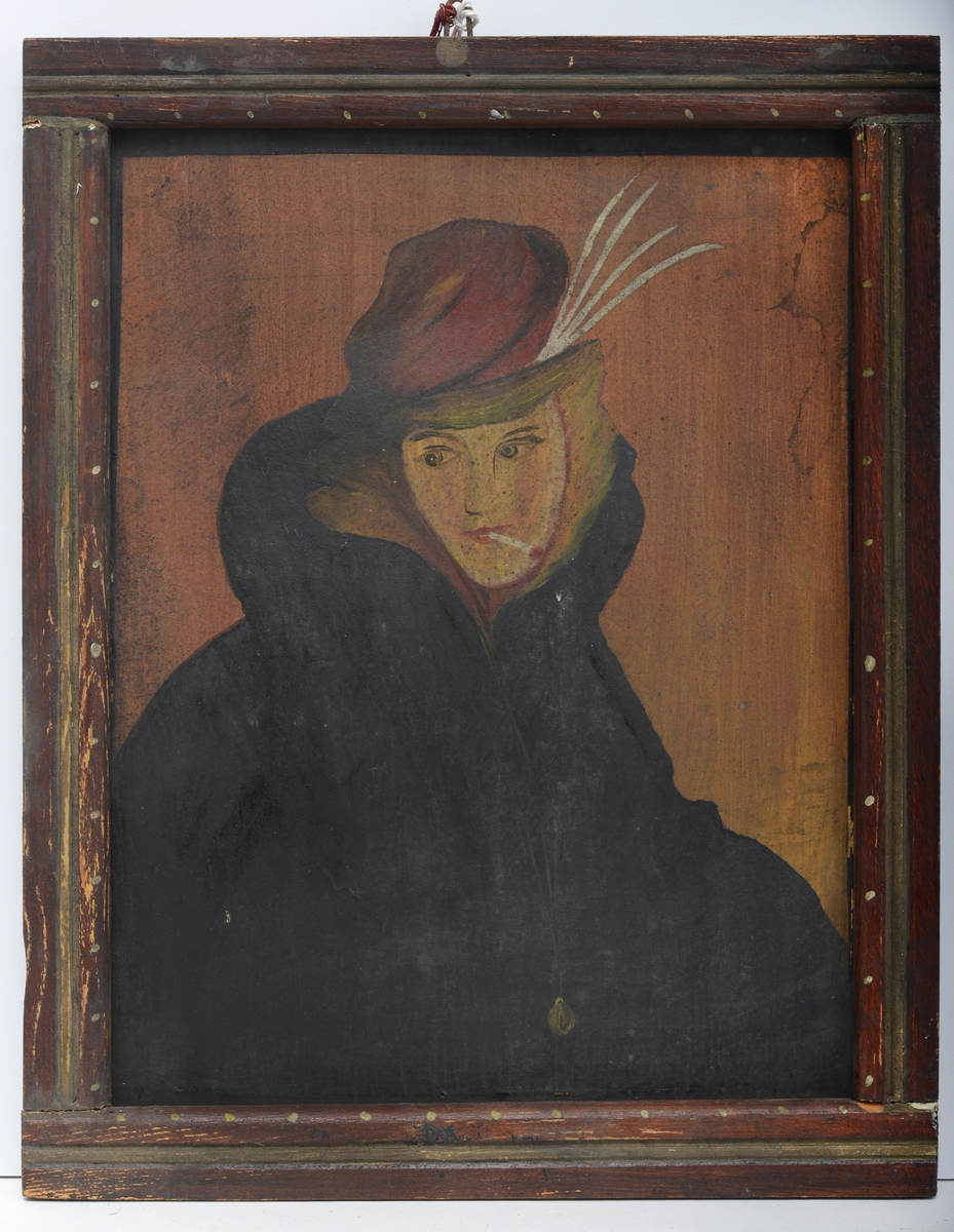 Portrett av en kvinne som har på seg en stor mørk kåpe og hatt, og hun har en sigarett i munnen.