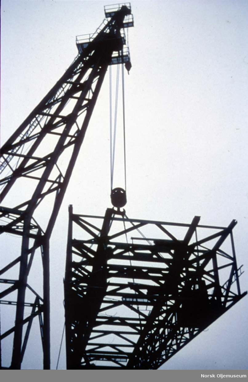 Kranskip heiser opp boretårnet på "Ocean Viking".