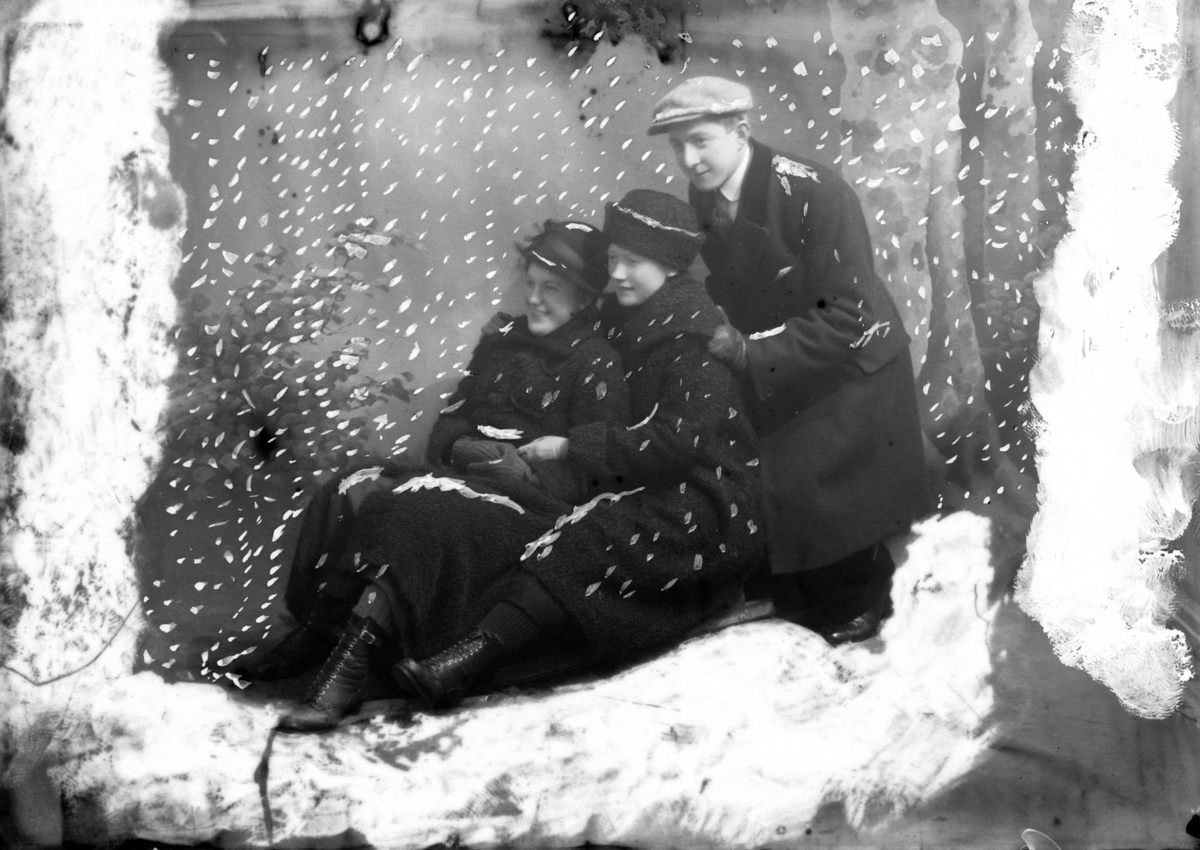 Studioportrett av to kvinner og en mann, med "snø" lagt på bildet av fotografen i etterkant.