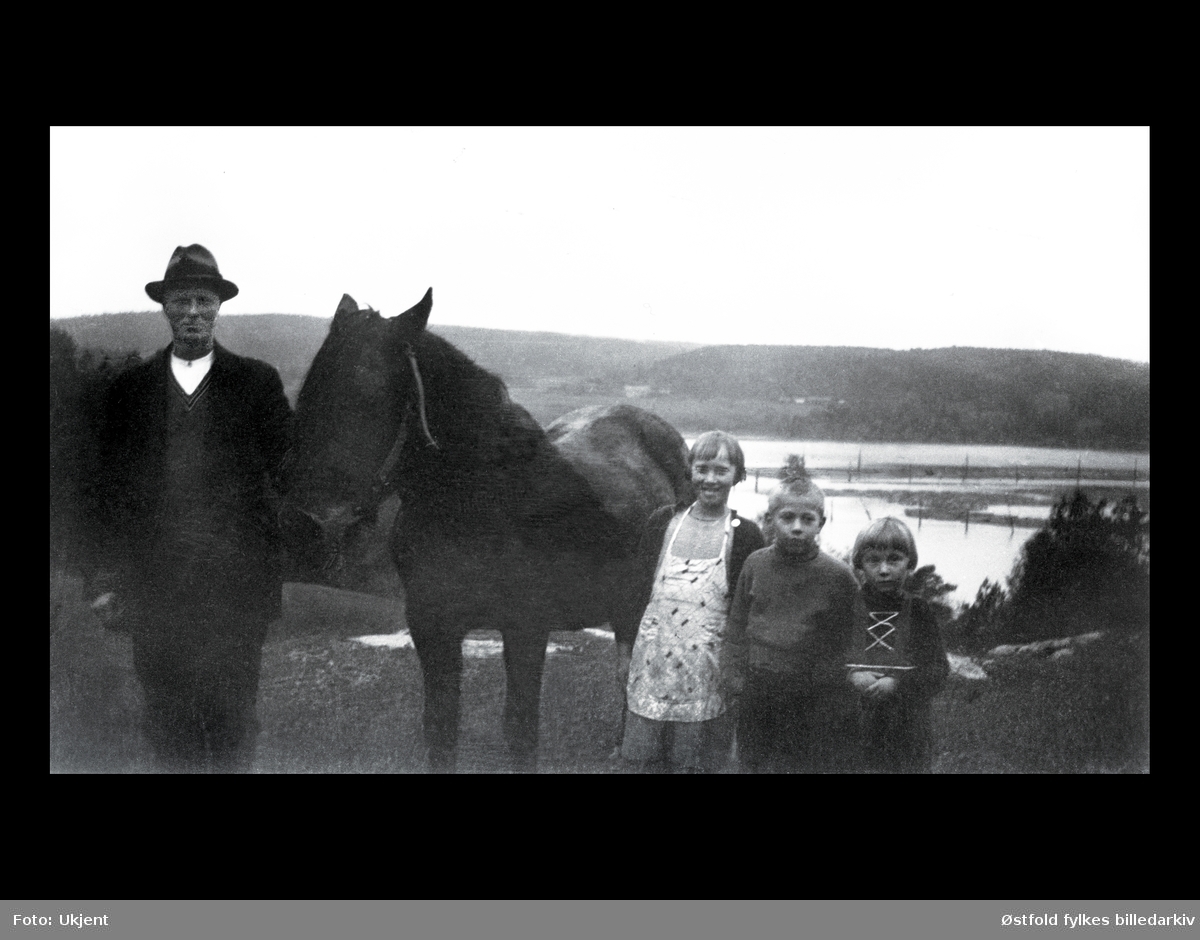 Fra gården Heden i 1939/40 ca. i Varteig. Hesten "Bruna". Fra venstre Olaf Bråten med barna Målfrid, Mathis og Thordis Bråten. Olaf var gårdbruker på gården Heden, samt lensearbeider. I bakgrunnen ser vi Glomma og Glennetangen lense.