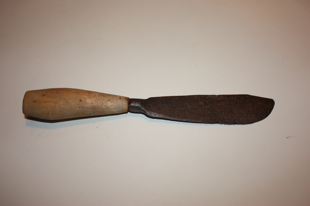 Kniven har breitt blad som endar i assymetrisk spiss.
