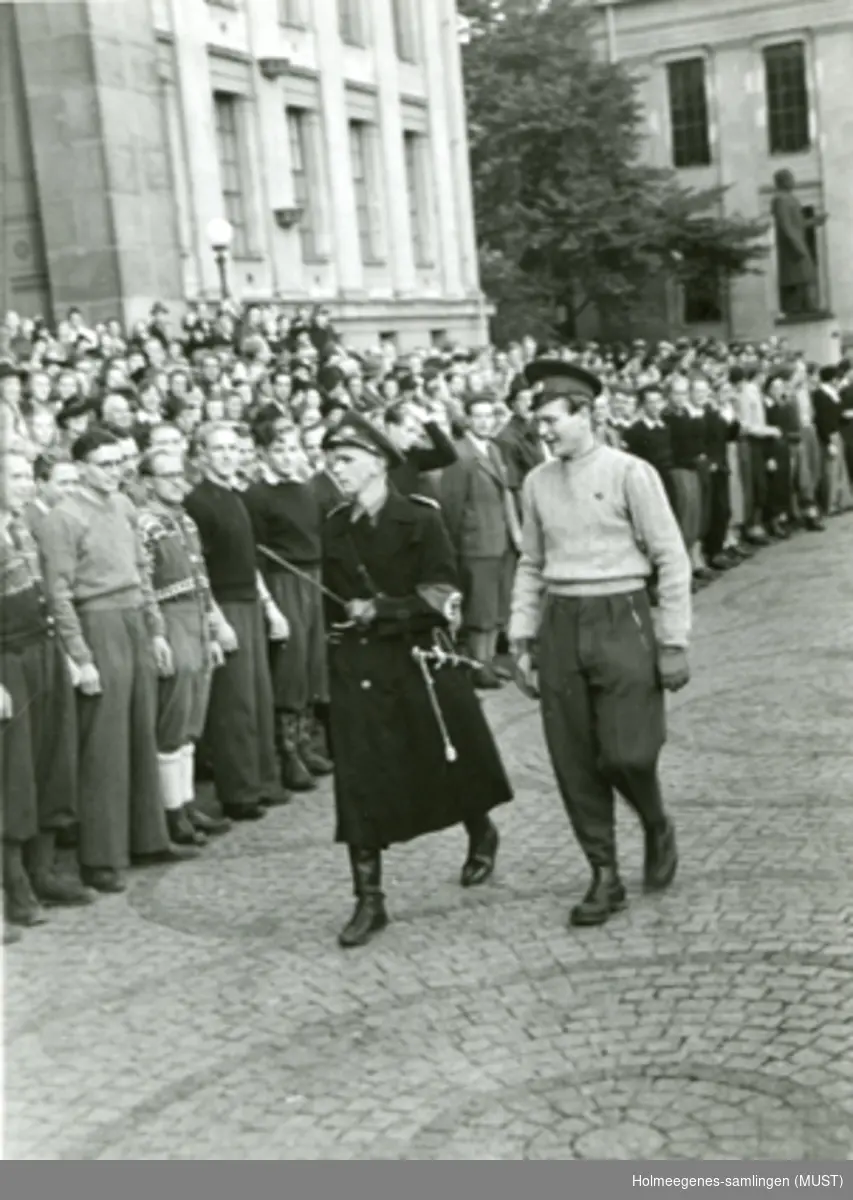 En menneskemengde utenfor Universitetet i Oslo. To personer i uniform "inspiserer".