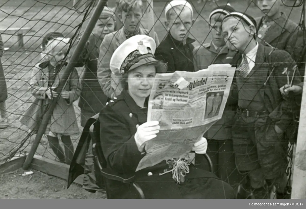 Politikvinne sitter og leser Dagbladet i et fotballmål! En flokk unger ser på gjennom nettet.