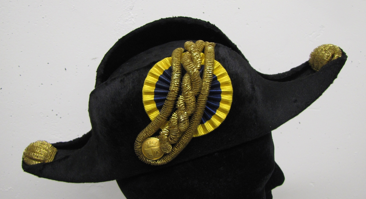 Civiluniformshatt medell 1885. Använd av länsman.
 

Blå-gul kokard. Snoddar i gulmetall.