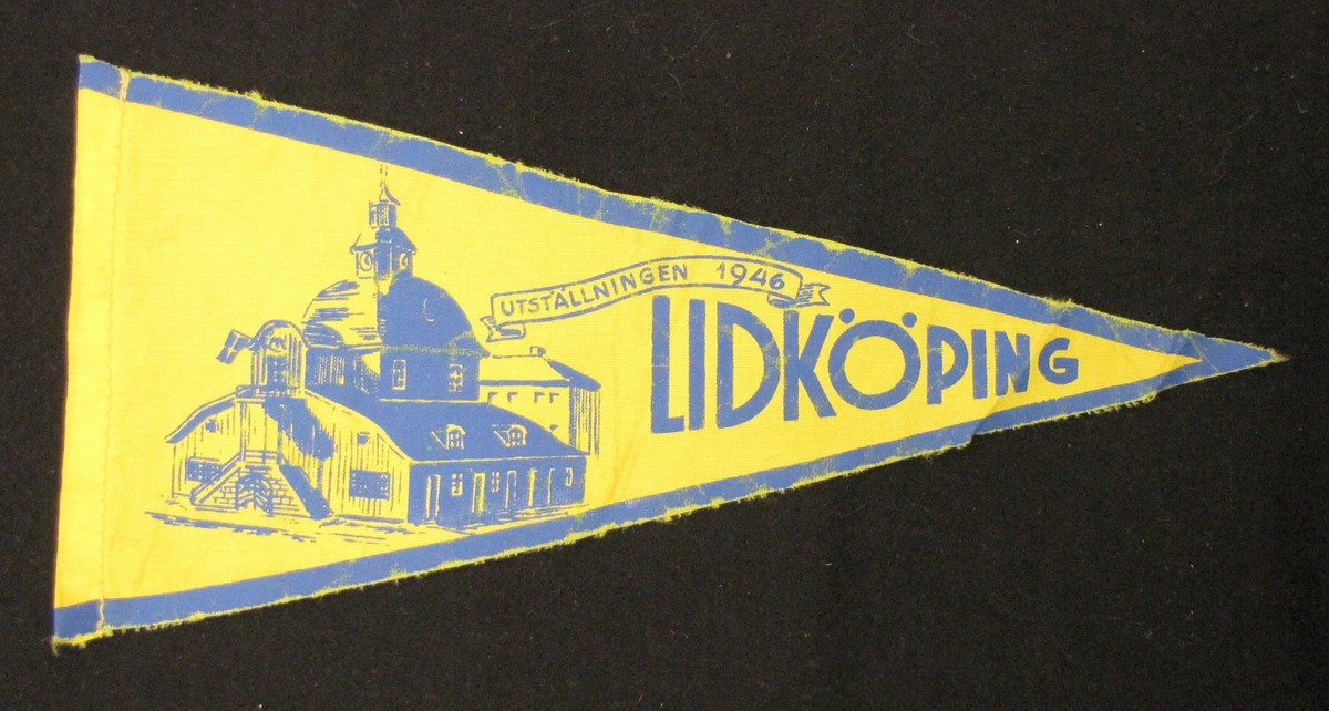 Cykelvimpel från Lidköping. Motivet är tryckt  med motiv av rådhuset och texten: utställningen 1946.

Vimpeln ingår i en samling av 103 stycken.